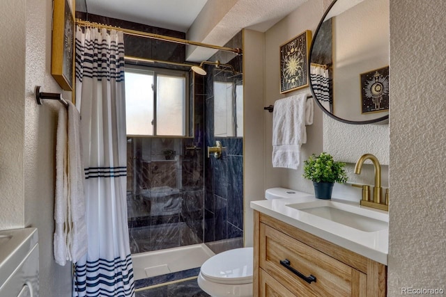 full bathroom with toilet, vanity, a tile shower, a textured wall, and washer / clothes dryer