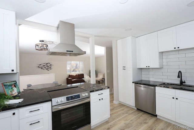 kitchen featuring dark stone countertops, ventilation hood, a sink, appliances with stainless steel finishes, and light wood-type flooring