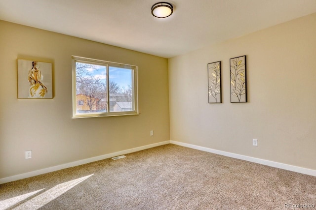 empty room featuring visible vents, carpet floors, and baseboards