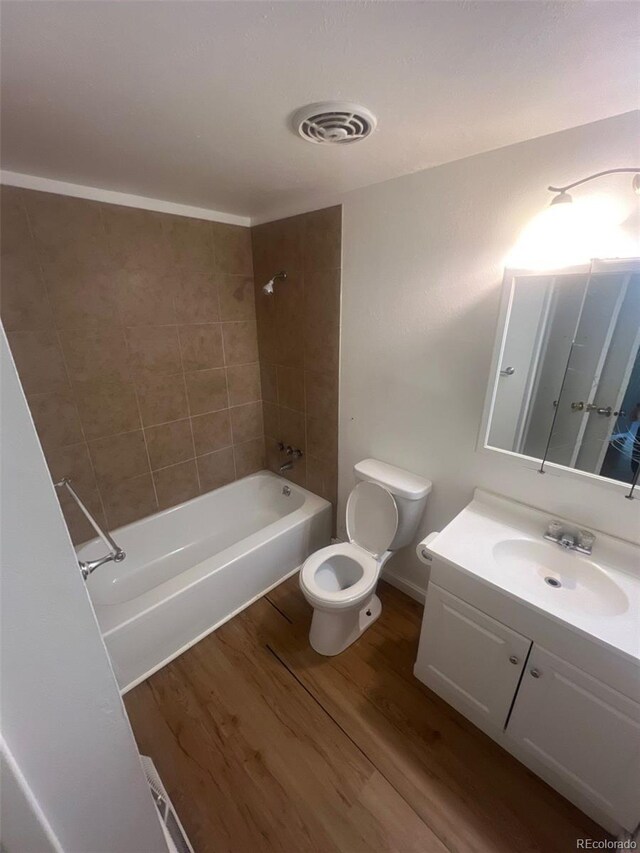 1533 S Jamaica St, Aurora, CO 80012 - full bath with toilet, wood finished floors, vanity, and shower / bathtub combination