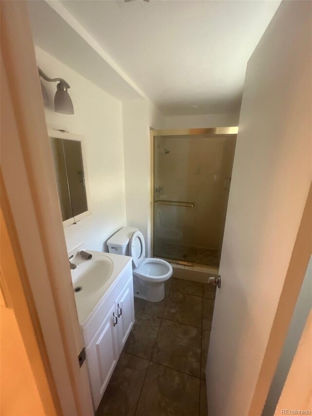1533 S Jamaica St, Aurora, CO 80012 - full bathroom with vanity, a shower stall, tile patterned flooring, and toilet