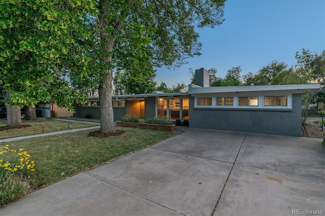 6057 S Windermere Way, Littleton, CO 80120 - view of front of property with a front yard, driveway, a chimney, and brick siding