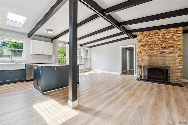 6057 S Windermere Way, Littleton, CO 80120 - unfurnished living room featuring a skylight, light wood finished floors, and a large fireplace