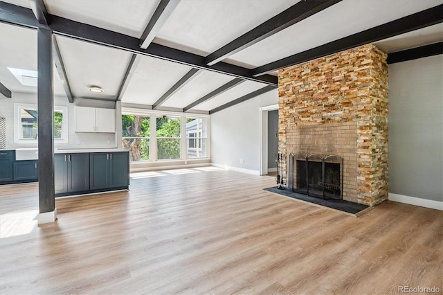 6057 S Windermere Way, Littleton, CO 80120 - unfurnished living room with healthy amount of natural light, light wood finished floors, and a fireplace