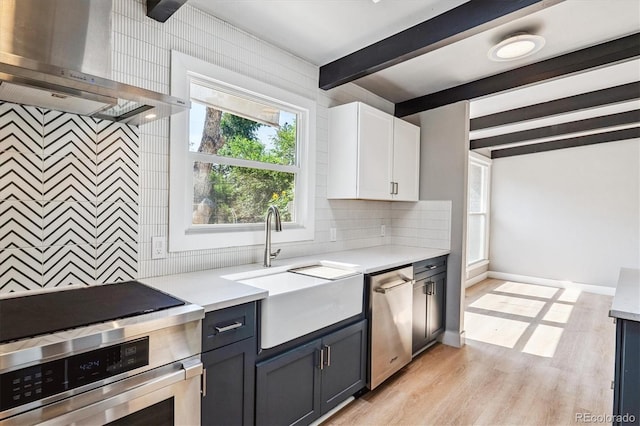 6057 S Windermere Way, Littleton, CO 80120 - kitchen featuring stainless steel appliances, wall chimney exhaust hood, beam ceiling, light countertops, and tasteful backsplash
