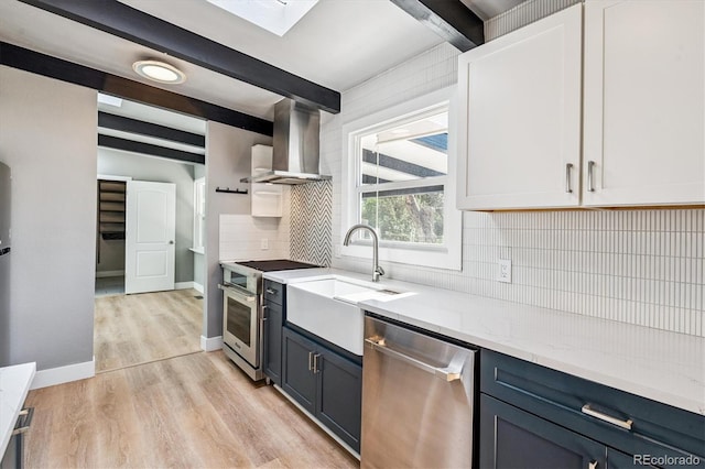 6057 S Windermere Way, Littleton, CO 80120 - kitchen with appliances with stainless steel finishes, wall chimney exhaust hood, beamed ceiling, tasteful backsplash, and light wood finished floors