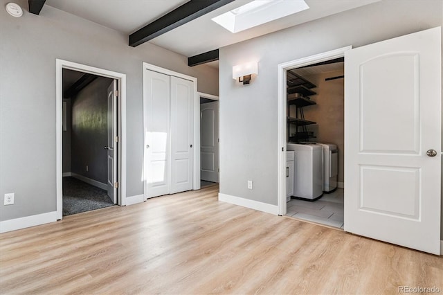 6057 S Windermere Way, Littleton, CO 80120 - unfurnished bedroom with separate washer and dryer, a skylight, wood finished floors, beam ceiling, and connected bathroom
