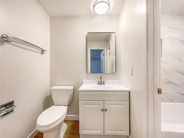 bathroom with vanity, toilet, a bathing tub, and hardwood / wood-style floors