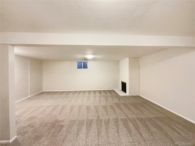 basement with carpet flooring, a fireplace, and a textured ceiling