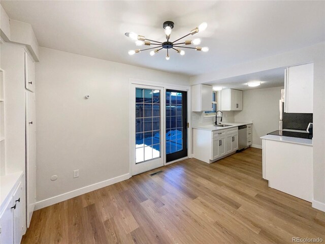 kitchen featuring sink, stainless steel dishwasher, white cabinets, and light hardwood / wood-style floors