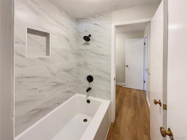 bathroom with tiled shower / bath combo and wood-type flooring