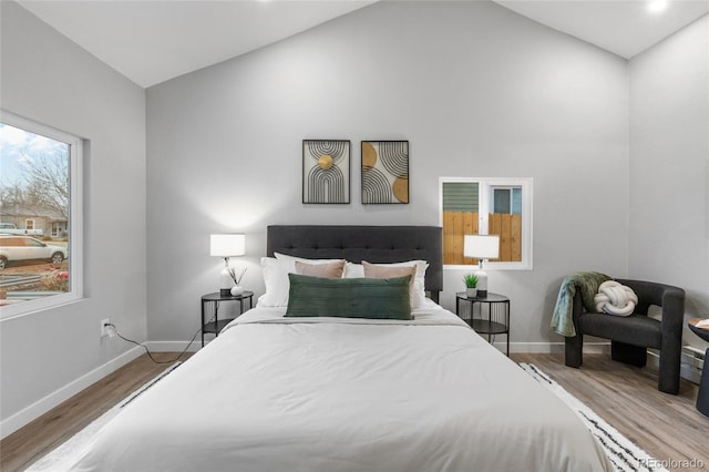 bedroom with wood-type flooring and vaulted ceiling