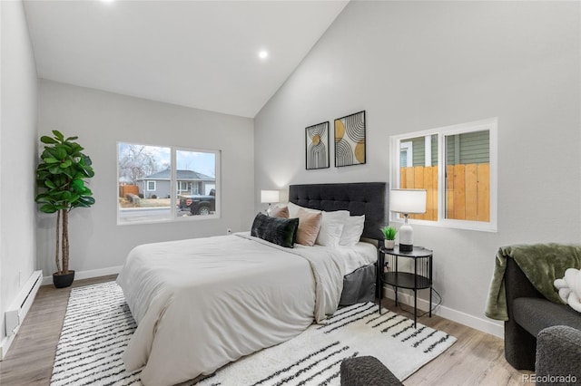 bedroom featuring hardwood / wood-style floors, a baseboard radiator, and high vaulted ceiling