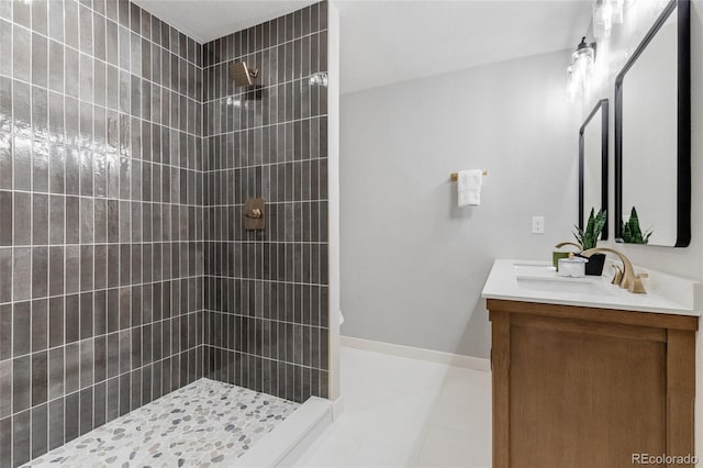 bathroom featuring a tile shower, tile patterned floors, and vanity