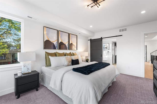 carpeted bedroom featuring a barn door