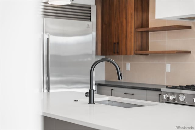 kitchen featuring decorative backsplash, white cabinetry, sink, and stainless steel appliances