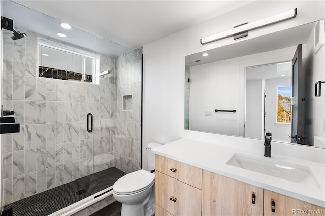 bathroom with a shower with door, vanity, and toilet