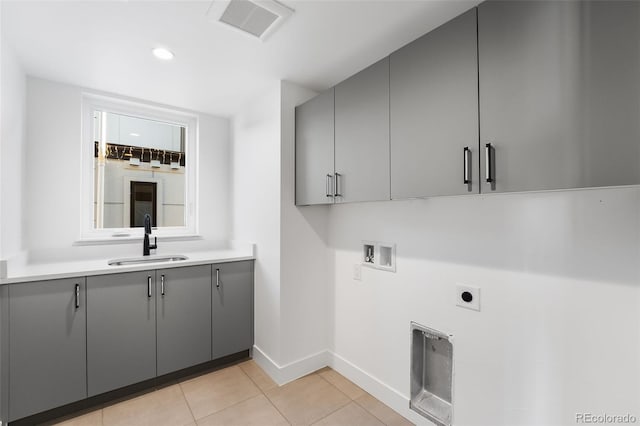 clothes washing area featuring electric dryer hookup, cabinets, sink, hookup for a washing machine, and light tile patterned flooring