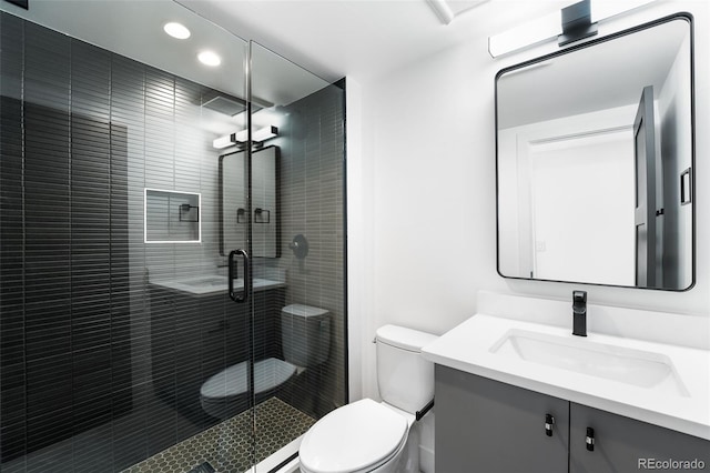 bathroom with vanity, toilet, and a shower with door