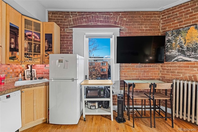 1450 N High St Unit 3, Denver, CO 80218 - kitchen with white appliances, radiator heating unit, brick wall, light brown cabinets, and light wood-style floors