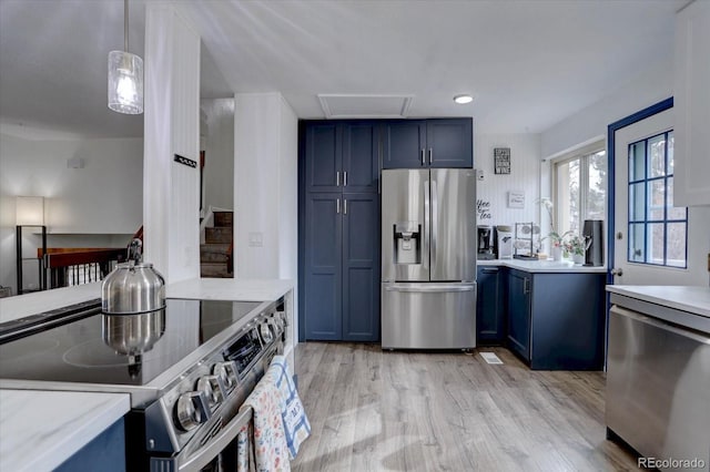 kitchen featuring blue cabinets, light wood finished floors, appliances with stainless steel finishes, and light stone counters