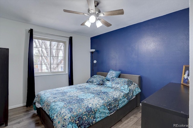 bedroom featuring wood finished floors and a ceiling fan