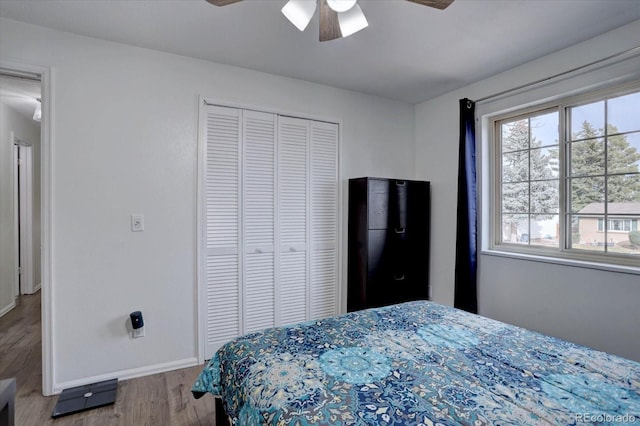 bedroom with ceiling fan, baseboards, a closet, and wood finished floors