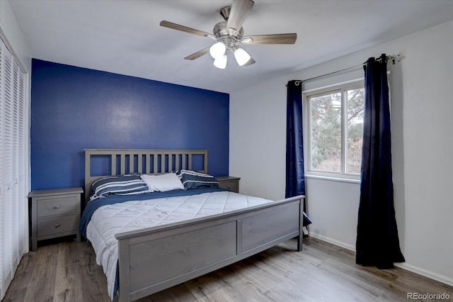 bedroom featuring ceiling fan, baseboards, and wood finished floors