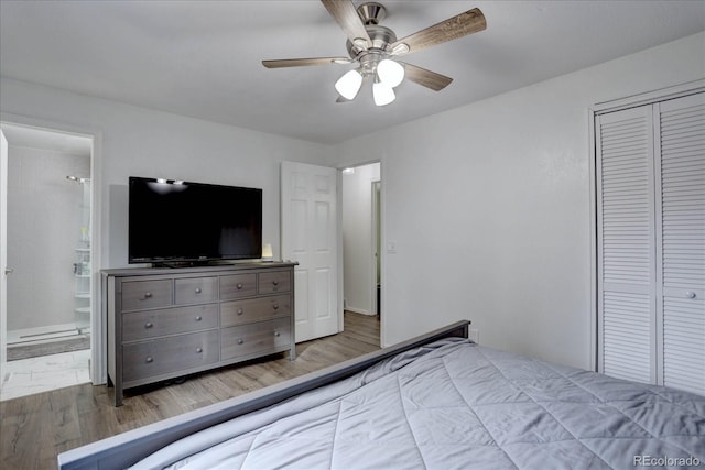 unfurnished bedroom with ensuite bath, a closet, ceiling fan, and wood finished floors