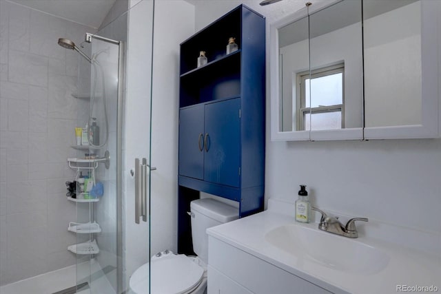 bathroom with vanity, a shower stall, and toilet