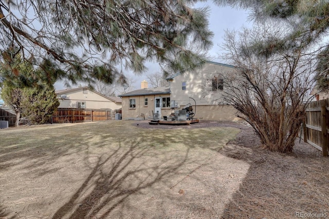 rear view of house featuring a yard, central AC, a chimney, and fence