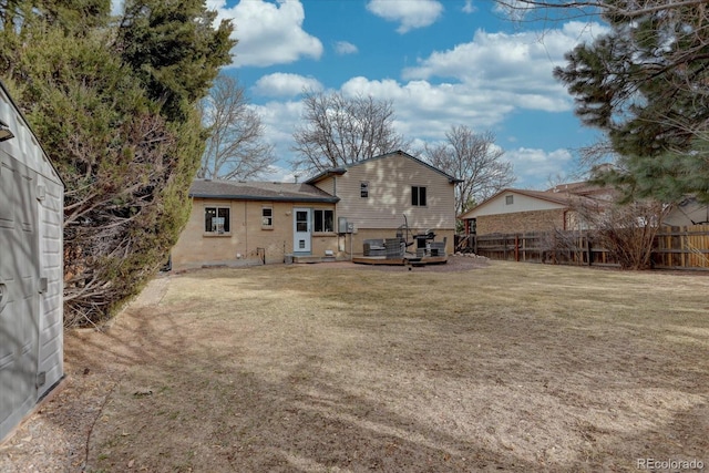 rear view of property with fence and a yard