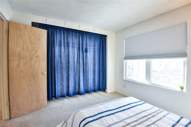 bedroom featuring light carpet and a textured ceiling