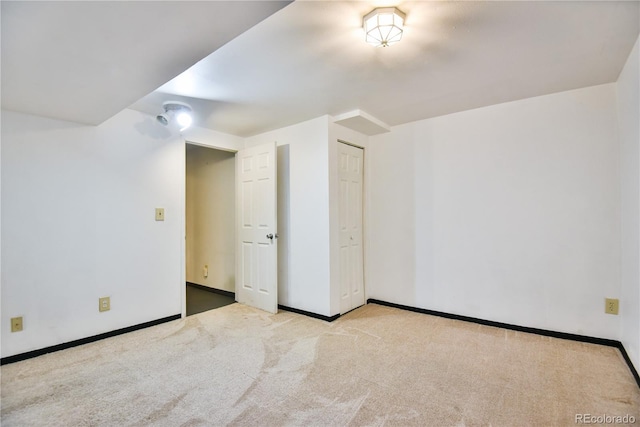 interior space with baseboards and light colored carpet