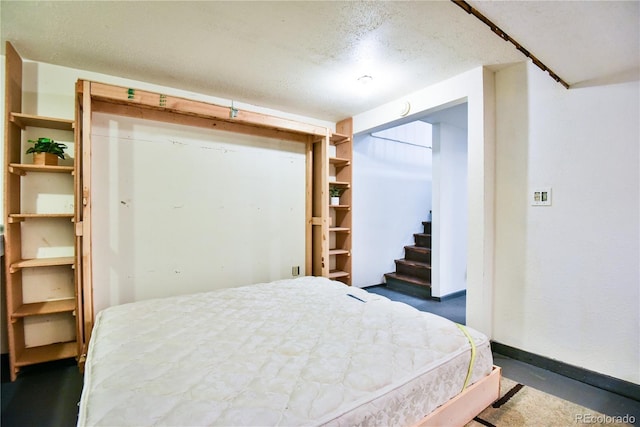 bedroom featuring a closet, baseboards, and a textured ceiling