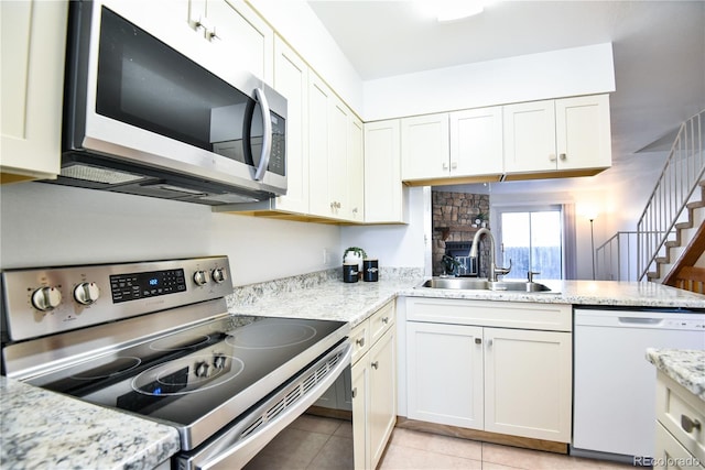 1641 S Idalia Cir Unit F, Aurora, CO 80017 - kitchen featuring appliances with stainless steel finishes, a sink, white cabinetry, and light tile patterned floors