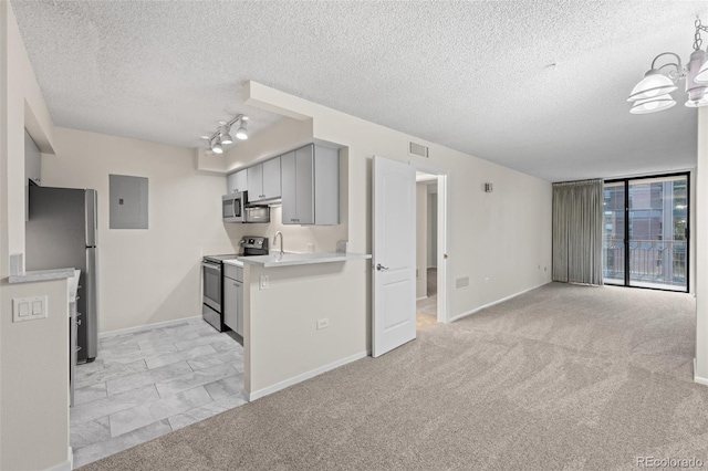 kitchen featuring appliances with stainless steel finishes, light carpet, rail lighting, and gray cabinetry