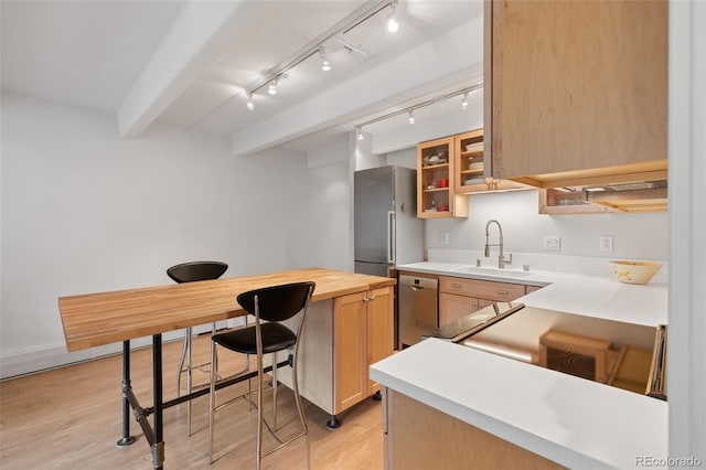 220 E Ln Bonte St Unit 317, Dillon, CO 80435 - kitchen featuring appliances with stainless steel finishes, a sink, light wood finished floors, glass insert cabinets, and beam ceiling