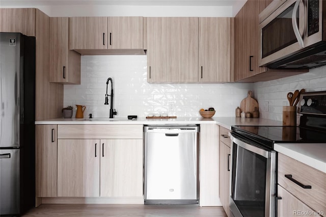 7395 E Eastman Ave Unit 202N, Denver, CO 80231 - kitchen featuring stainless steel appliances, light brown cabinetry, a sink, light countertops, and backsplash