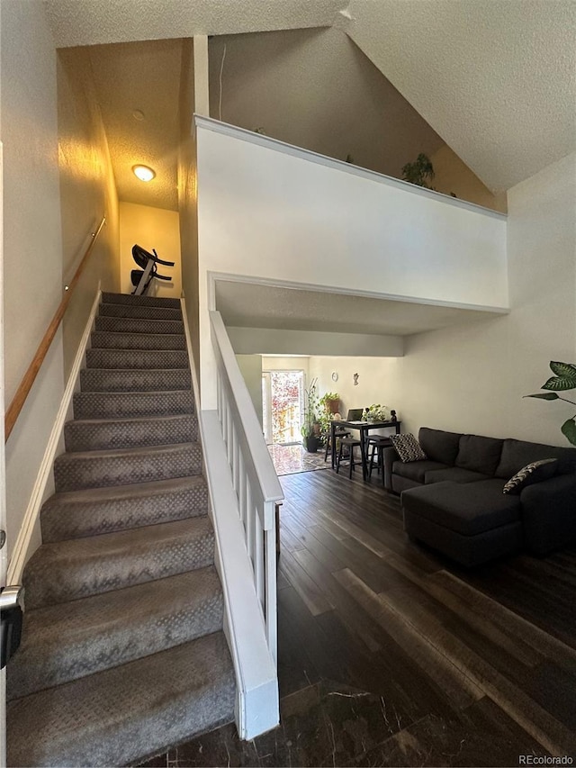 11576 E Bayaud Dr, Aurora, CO 80012 - stairs with a textured ceiling, wood finished floors, and high vaulted ceiling