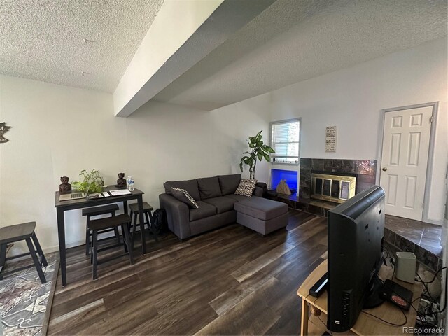 11576 E Bayaud Dr, Aurora, CO 80012 - living room with a textured ceiling, dark wood-style floors, and a fireplace