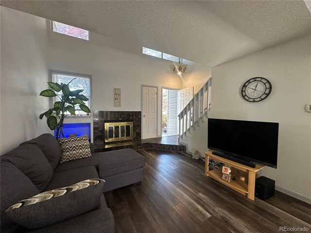 11576 E Bayaud Dr, Aurora, CO 80012 - living area featuring wood finished floors, a textured ceiling, stairway, a fireplace, and baseboards