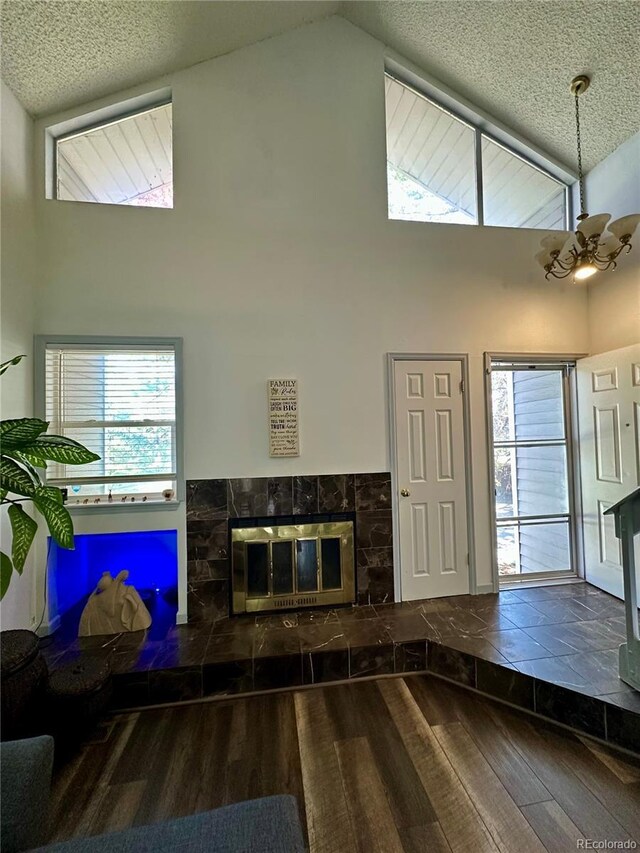 11576 E Bayaud Dr, Aurora, CO 80012 - entrance foyer featuring wood-type flooring, a chandelier, high vaulted ceiling, a textured ceiling, and healthy amount of natural light