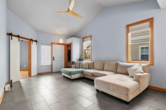 living room with a barn door, vaulted ceiling, and ceiling fan