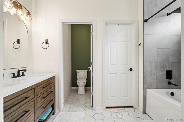 full bathroom featuring tile patterned floors, vanity, toilet, and tiled shower / bath combo