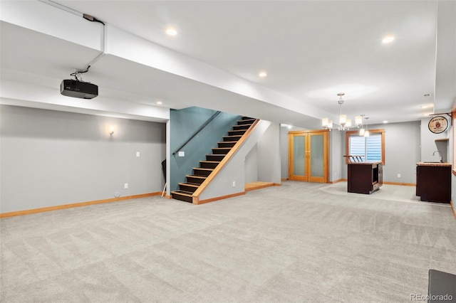 basement with light colored carpet and a chandelier