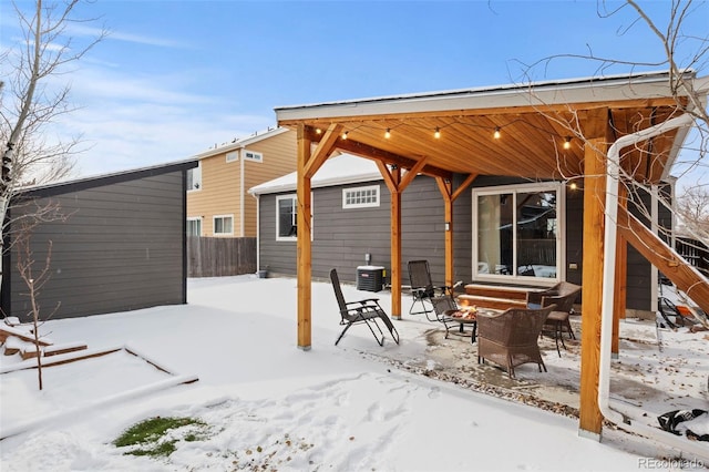 snow covered house featuring central AC unit