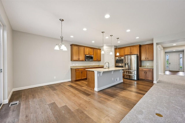17710 E Emilia Dr, Parker, CO 80134 - kitchen featuring appliances with stainless steel finishes, recessed lighting, brown cabinets, a breakfast bar area, and dark wood finished floors