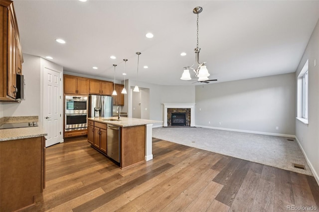 17710 E Emilia Dr, Parker, CO 80134 - kitchen with appliances with stainless steel finishes, dark wood-style flooring, recessed lighting, brown cabinetry, and a chandelier