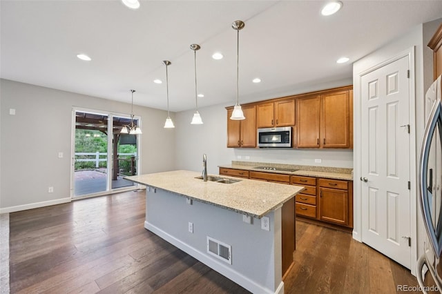 17710 E Emilia Dr, Parker, CO 80134 - kitchen featuring stainless steel microwave, black electric cooktop, brown cabinetry, dark wood-style flooring, and recessed lighting